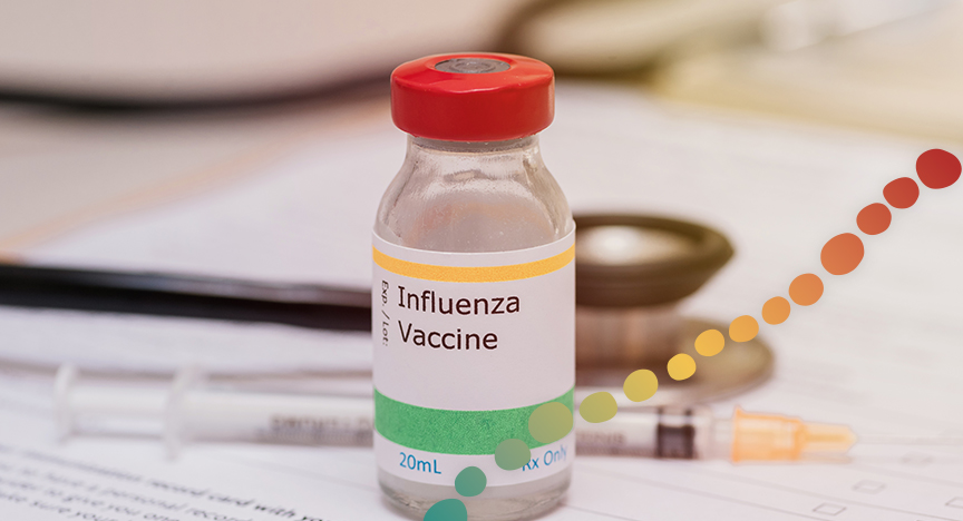 Influenza vaccine vile on desk with consent form, needle and stethoscope 