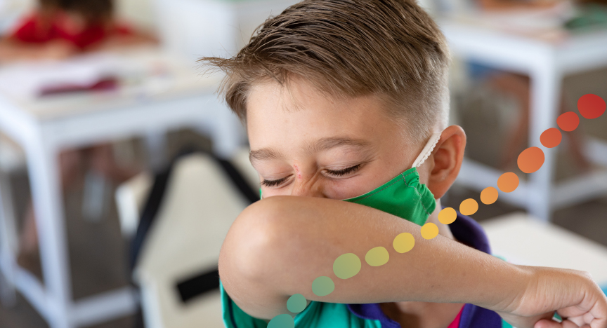 Young boy, coughing into his elbow